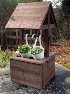 A wood garden planter in the style of a wishing-well.